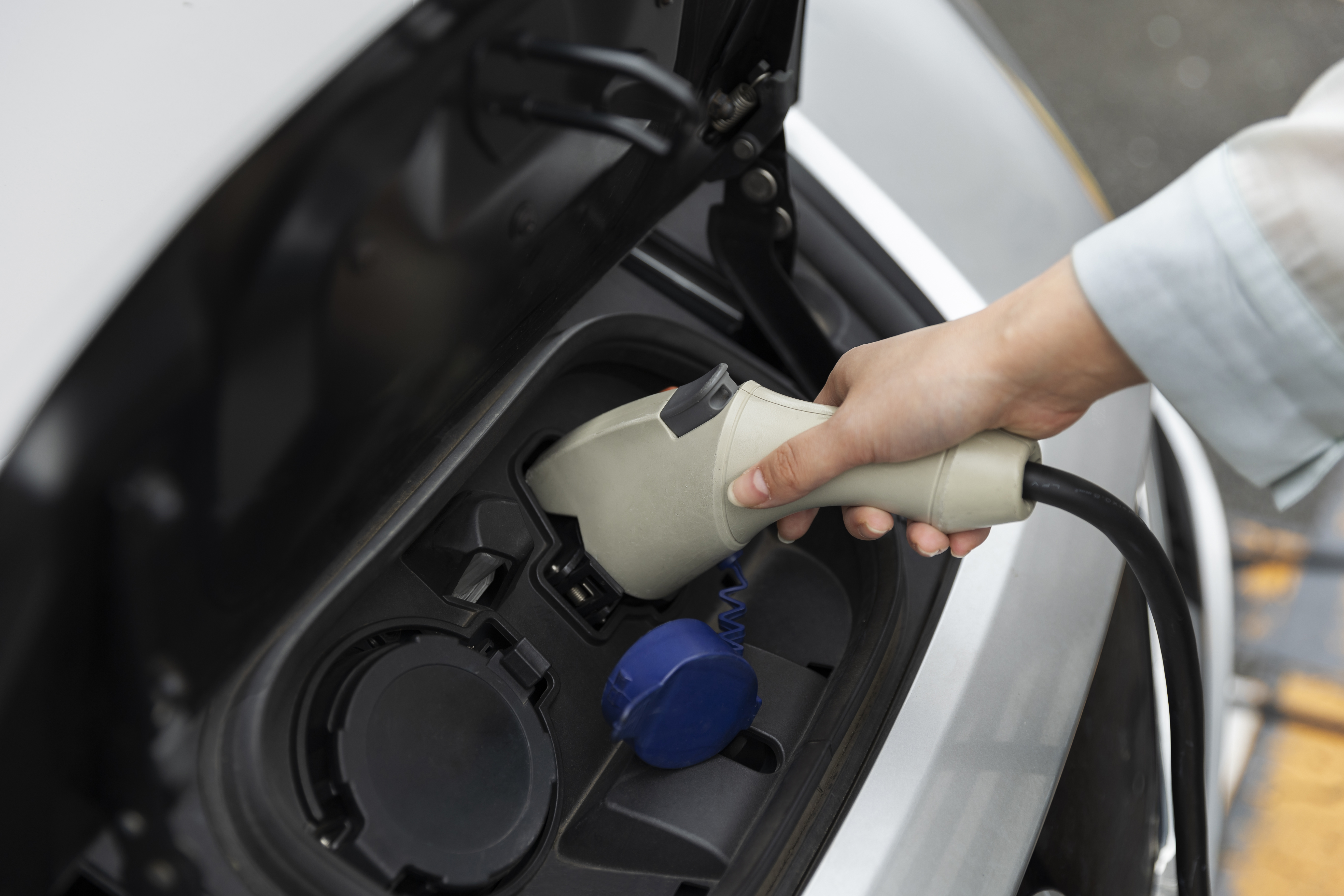 Woman charging her electric car station